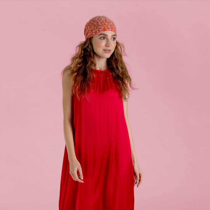Quadratisches, kleines Kaschmirtuch bedruckt mit einem Leoprint Herzmuster aus 100% reinem Kaschmir für Damen in der Farbe Pink, Styling-Möglichkeit das Bandana als Kopftuch zu tragen, Modelbild