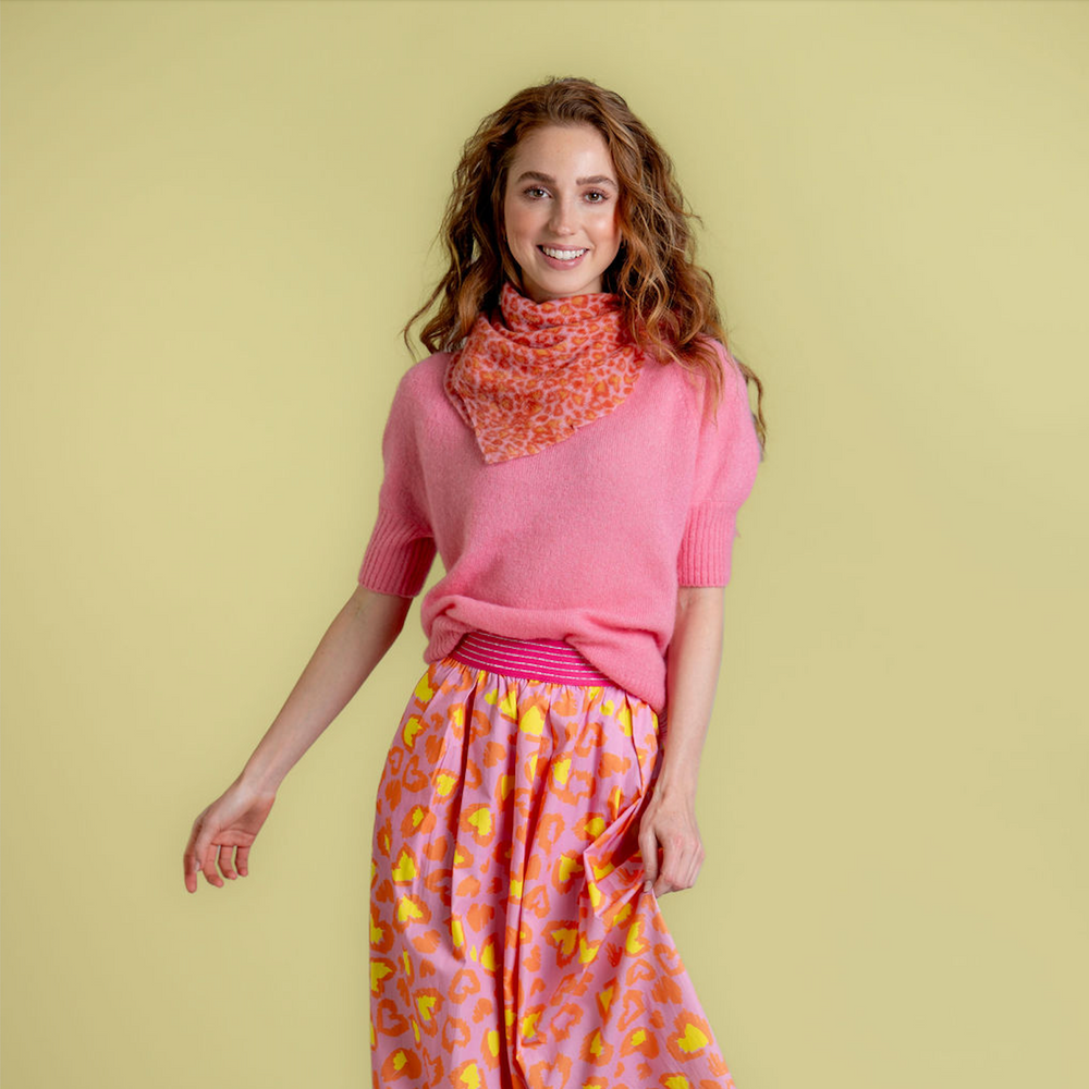 Quadratisches, kleines Kaschmirtuch bedruckt mit einem Leoprint Herzmuster aus 100% reinem Kaschmir für Damen in der Farbe Pink, Styling-Idee als Halstuch getragen