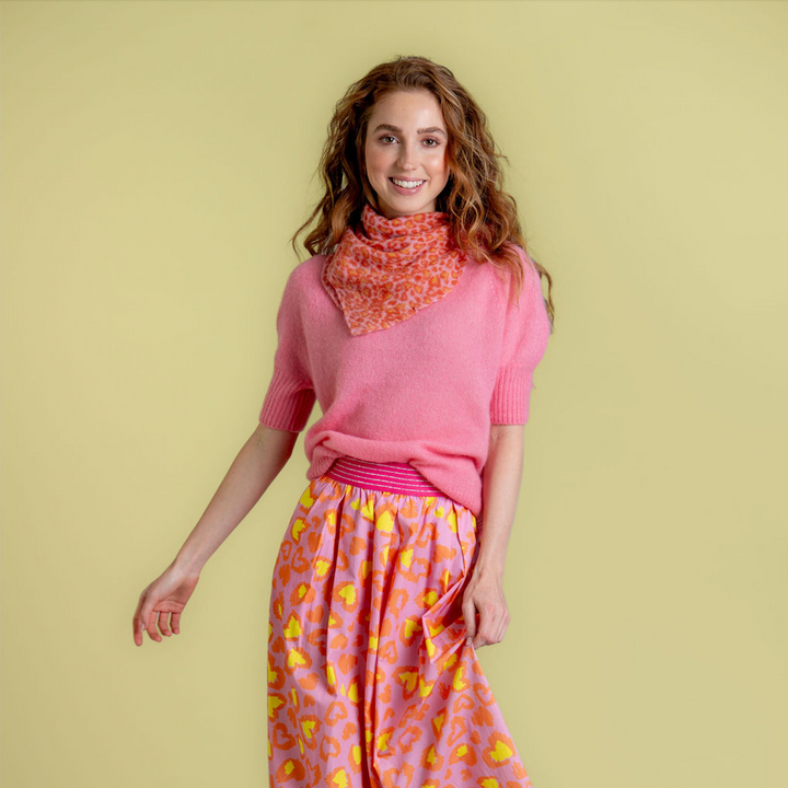 Quadratisches, kleines Kaschmirtuch bedruckt mit einem Leoprint Herzmuster aus 100% reinem Kaschmir für Damen in der Farbe Pink, Styling-Idee als Halstuch getragen