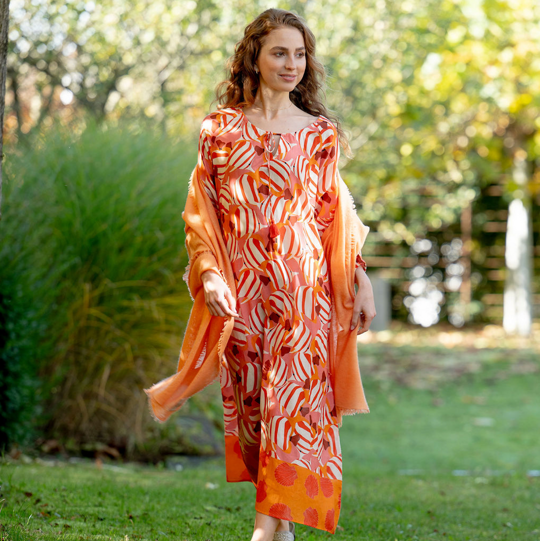 Weicher Kaschmirschal für Damen in der Farbe Nektarine mit dezenten Fransen, gestrickt und gefilzt, 100% Kaschmir, Model trägt den Schal über die Schultern gelegt