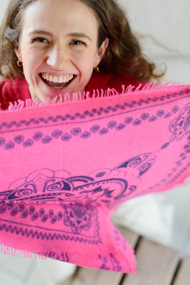 Model hält das kaschmir Bandana mit Ornament Muster in neonpink vor dem Körper