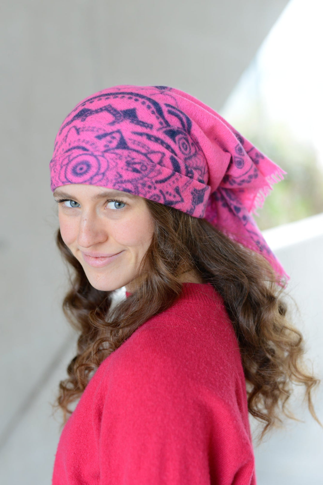 Model stylt das Kaschmir-Bandana in Neonpink mit Ornament-Muster als Kopftuch