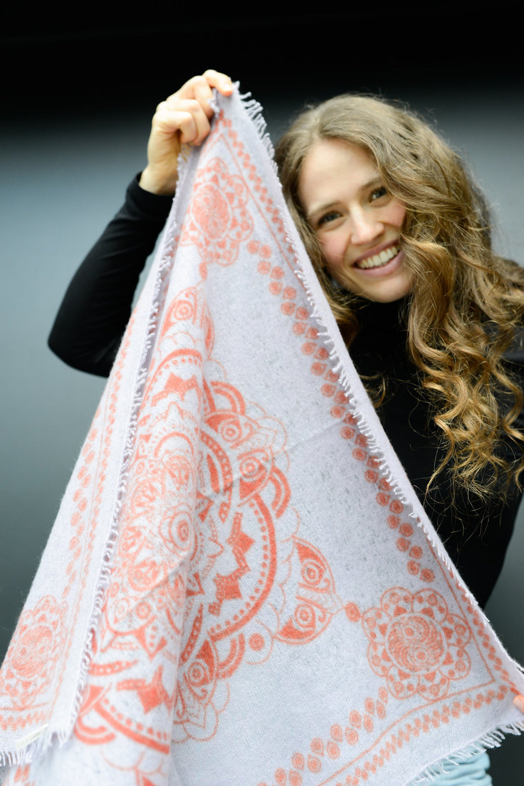 Model hält Kaschmir-Bandana in der Farbe Lavender mit Ornament-Muster vor dem Körper