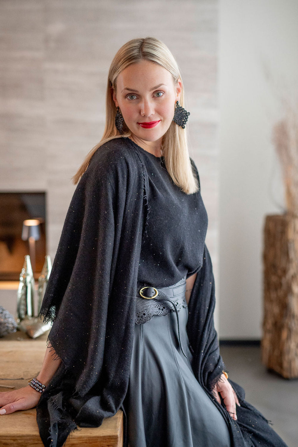 Eleganter Kaschmirschal für Damen aus reinem Kaschmir mit feinen, eingearbeiteten Pailletten und mit dezenten Fransen in der Farbe Schwarz, Model trägt Shal über den Schultern