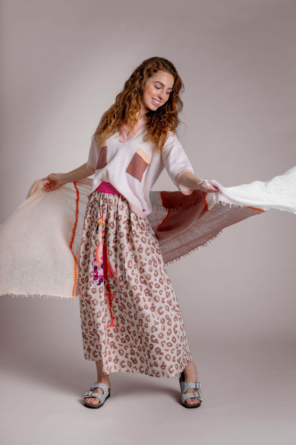 Kaschmirschal mit Blockstreifen in Naturfarben und Kreuzstich-Stickerei in Magnolia aus 100 % Cashmere, Model svhwingt den Schal