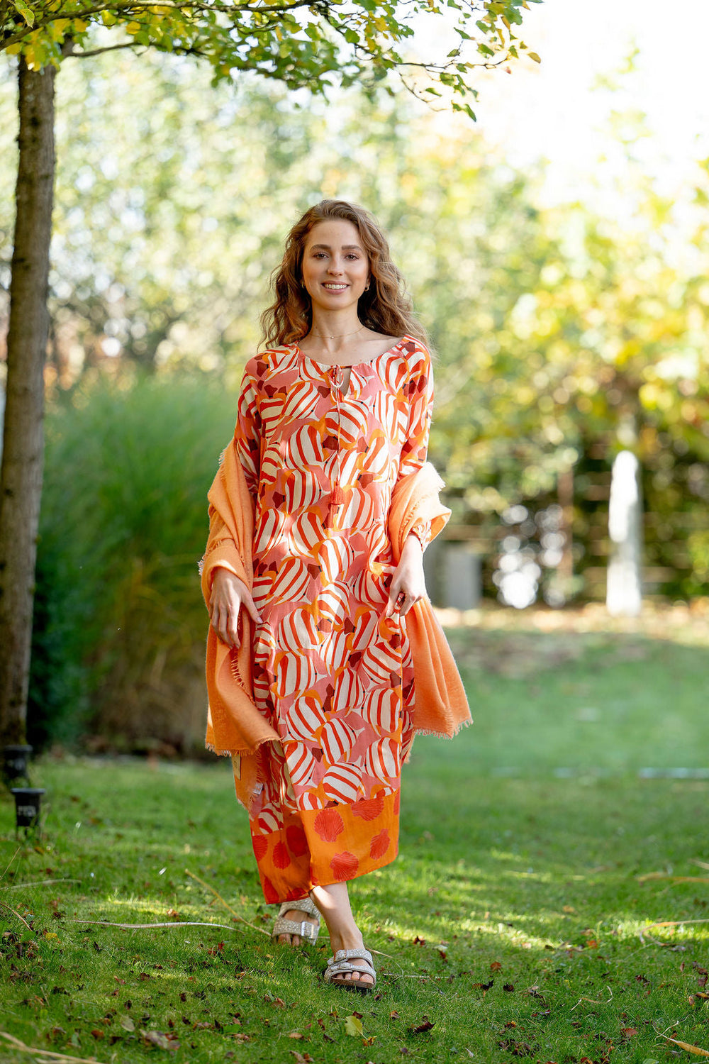Model trägt langes Baumwoll Sommerkleid Megan‑cs mit Fisch‑Print in Champagner, gestylt mit einem Kaschmirschal in Orange
