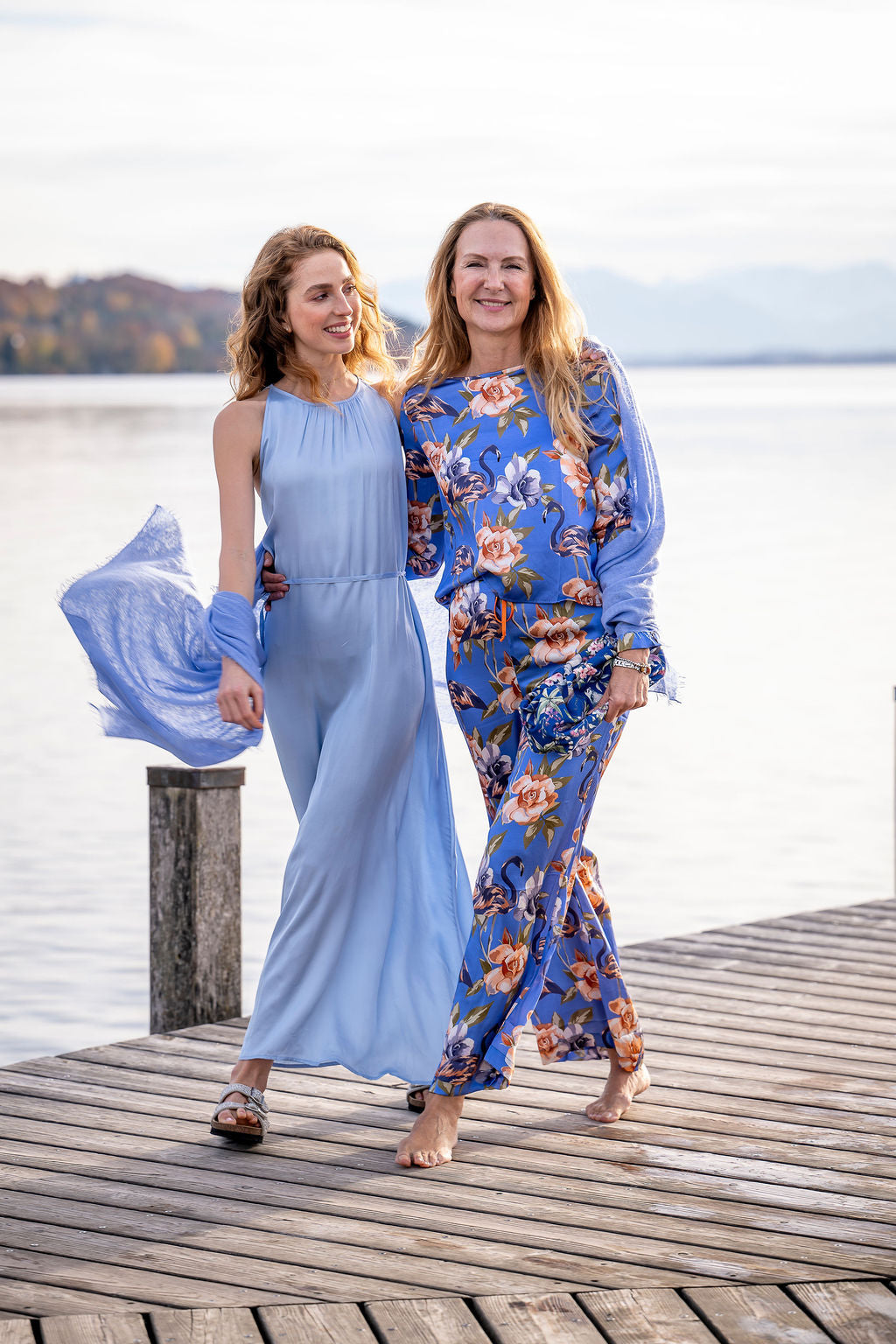 Model kombiniert die Seidenhose Gracia-cs mit Flamingo-Print mit Seidenbluse und Clutch in Blau