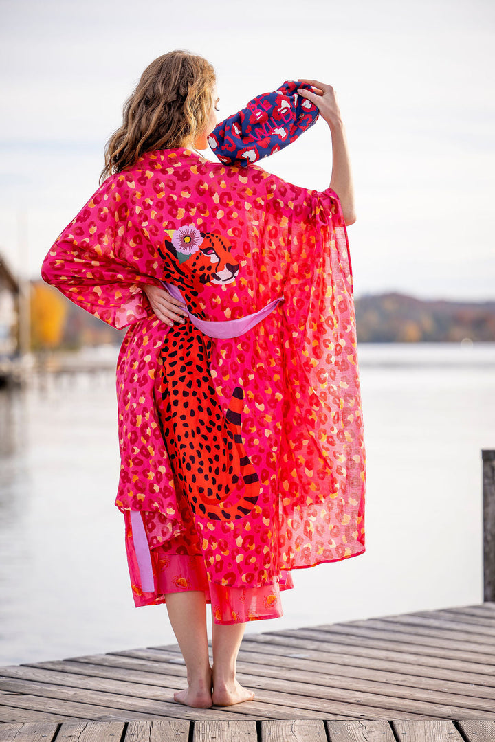

Model trägt Baumwollkimono Catalina‑cs in Pink am See, Rückansicht mit Leopraden-Print

