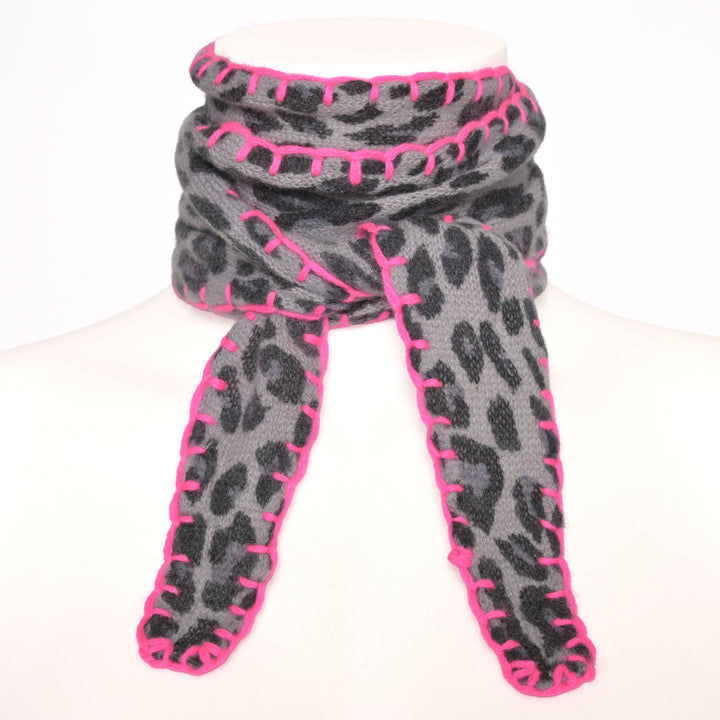 Feiner Kaschmirschal Ella mit Leoprint in Schwwarz und Stitchingkante in Neonpnk auf weißem Hintergrund fotografiert