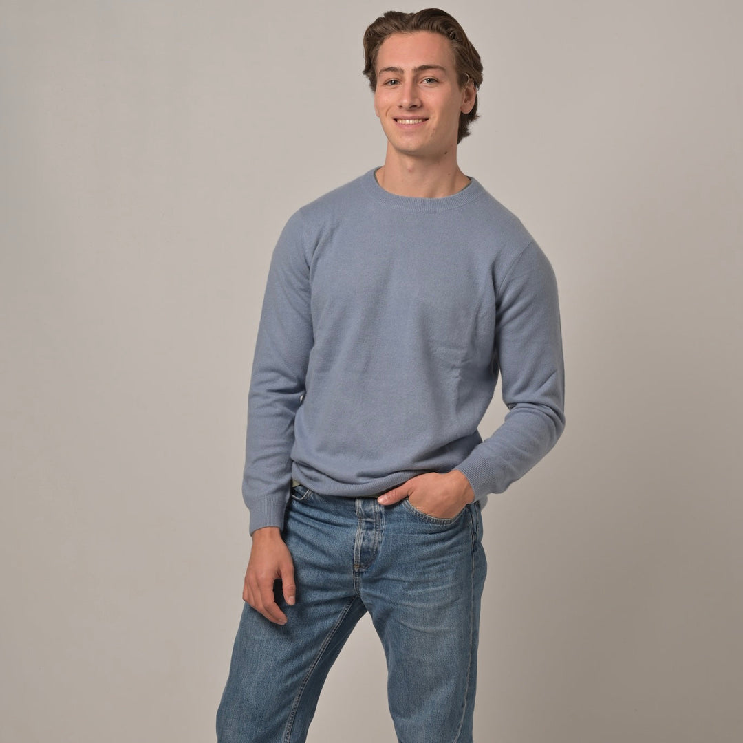 Model trägt Klassischen Herren-Kaschmirpullover mit Rundhalsausschnitt in Denim aus 100 % Kaschmir