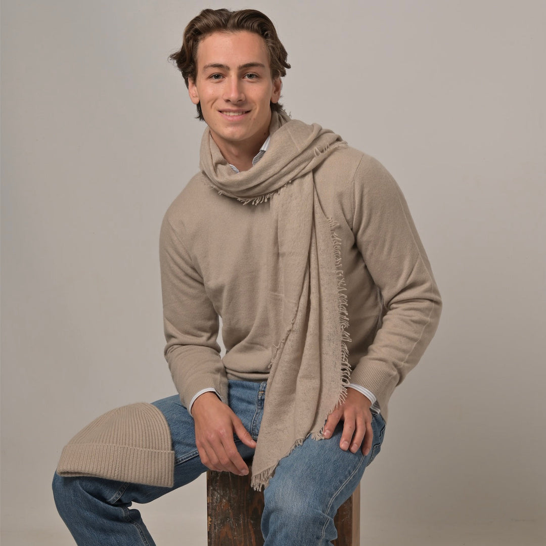 Model trägt Klassischen Herren-Kaschmirpullover mit Rundhalsausschnitt in Ice aus 100 % Kaschmir, dazu einen Light Cashmere Schal Tiny-cs und eine Kaschmirmütze Nina-s