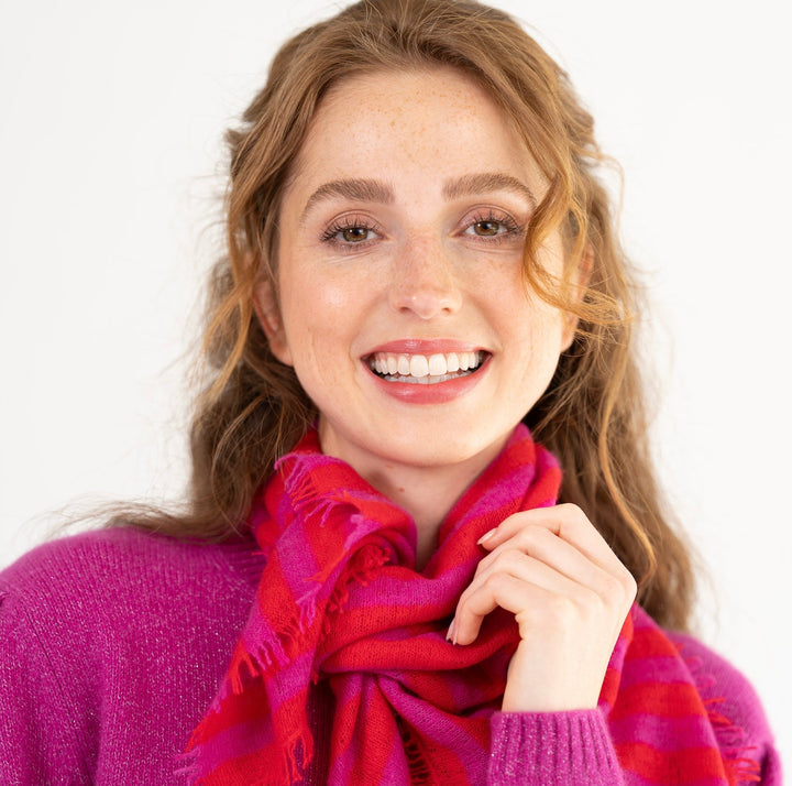 Model trät das gestreifte Kaschmir-Bandana in Wild Berry von cute stuff als Tuch um den Hals