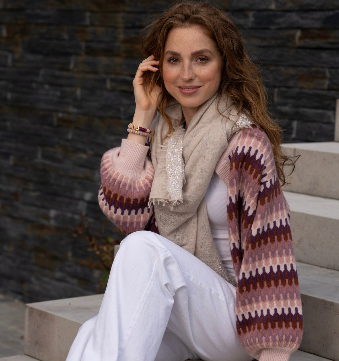 Ansicht der weiten Ärmel, auf dem Bild trägt das Model die Strickjacke Liv-cs mit ZigZag-Muster in der Farbe Rosty Rose aus 100% Kaschmir zu einem Kaschmirtuch