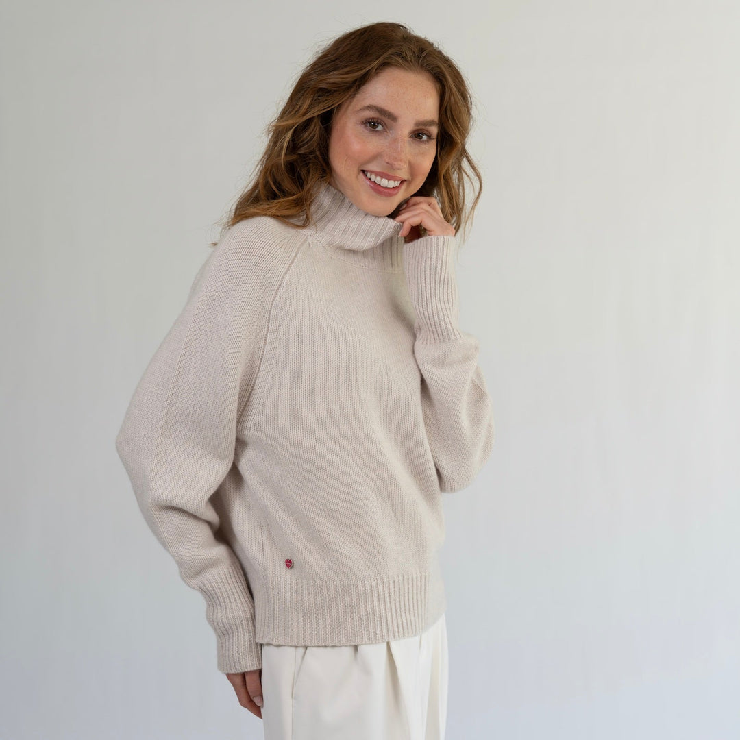 Model trägt Kaschmirpullover Alex mit Turtle Neck und gerippten Bündchen lässig und casual zu einer Hose