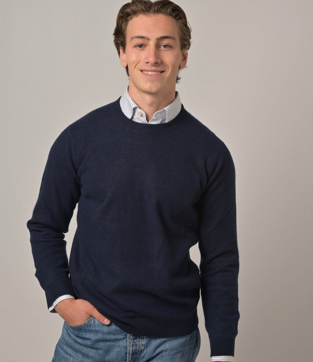 Model trägt klassischen Herren-Kaschmirpullover mit Rundhalsausschnitt in Nachtblau aus 100 % Kaschmir ü+ber einem Herrenhemd