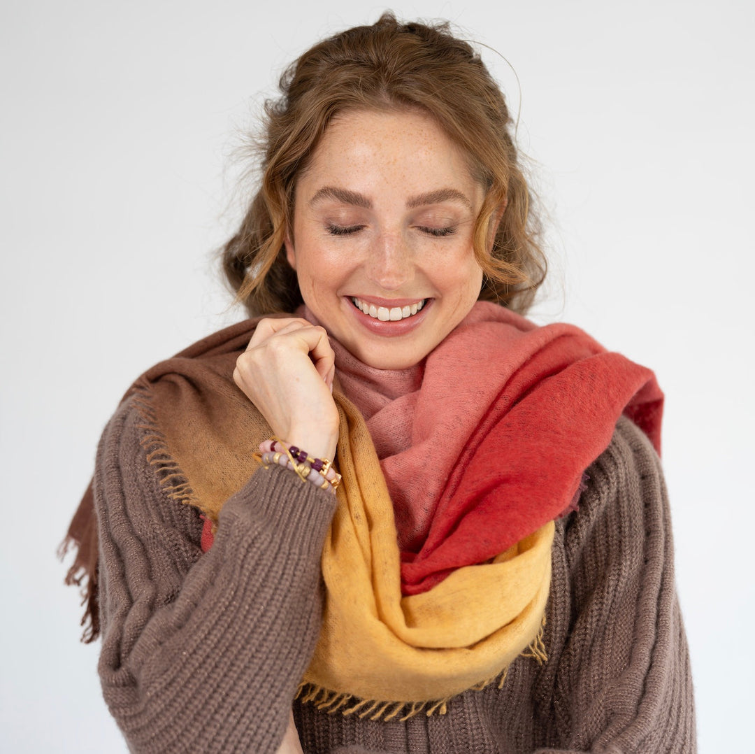 Kaschmir-Schal „Tabita“ aus 100 % Light Cashmere mit kleinen Fransen in Koralle mit Farbverlauf zu Braun und Lila von cute stuff  getragen als Schal um den Hals gewickelt