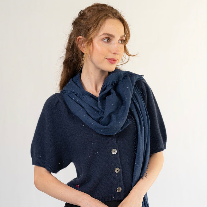 Modell trägt Kaschmirschal Adele mit Pailletten in Nachtblau elegant als Schal um den Hals gewickelt zum Kaschmir Cardigan Luca in Nachtblau