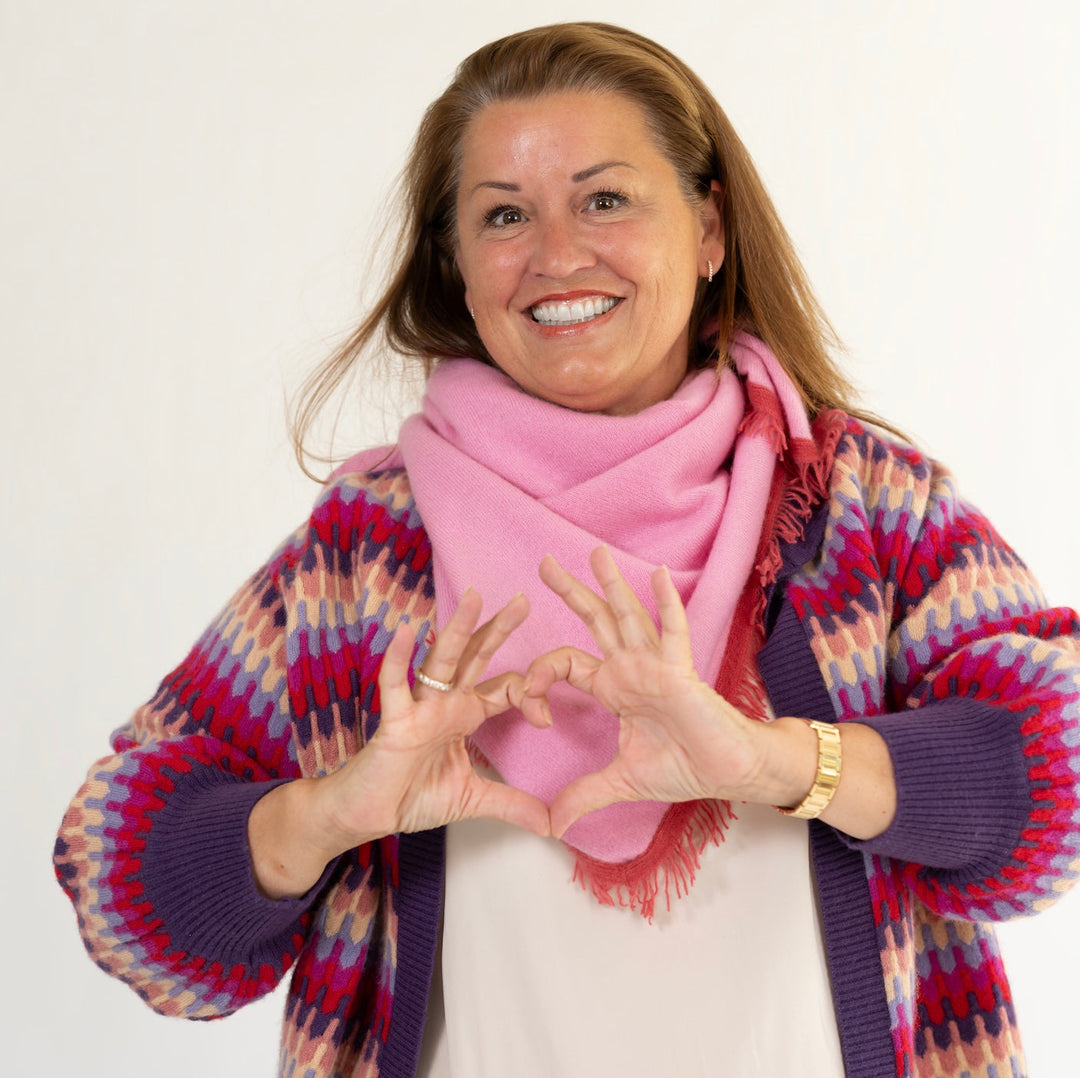 Corinna trägt das gestrickte Kaschmirtuch Mila-cs in Pink von cute stuff als Halstuch und kombiniert es mit der Strickjacke Liv