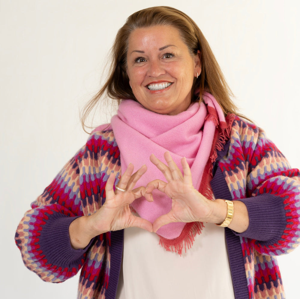 Corinna trägt das gestrickte Kaschmirtuch Mila-cs in Pink von cute stuff als Halstuch und kombiniert es mit der Strickjacke Liv